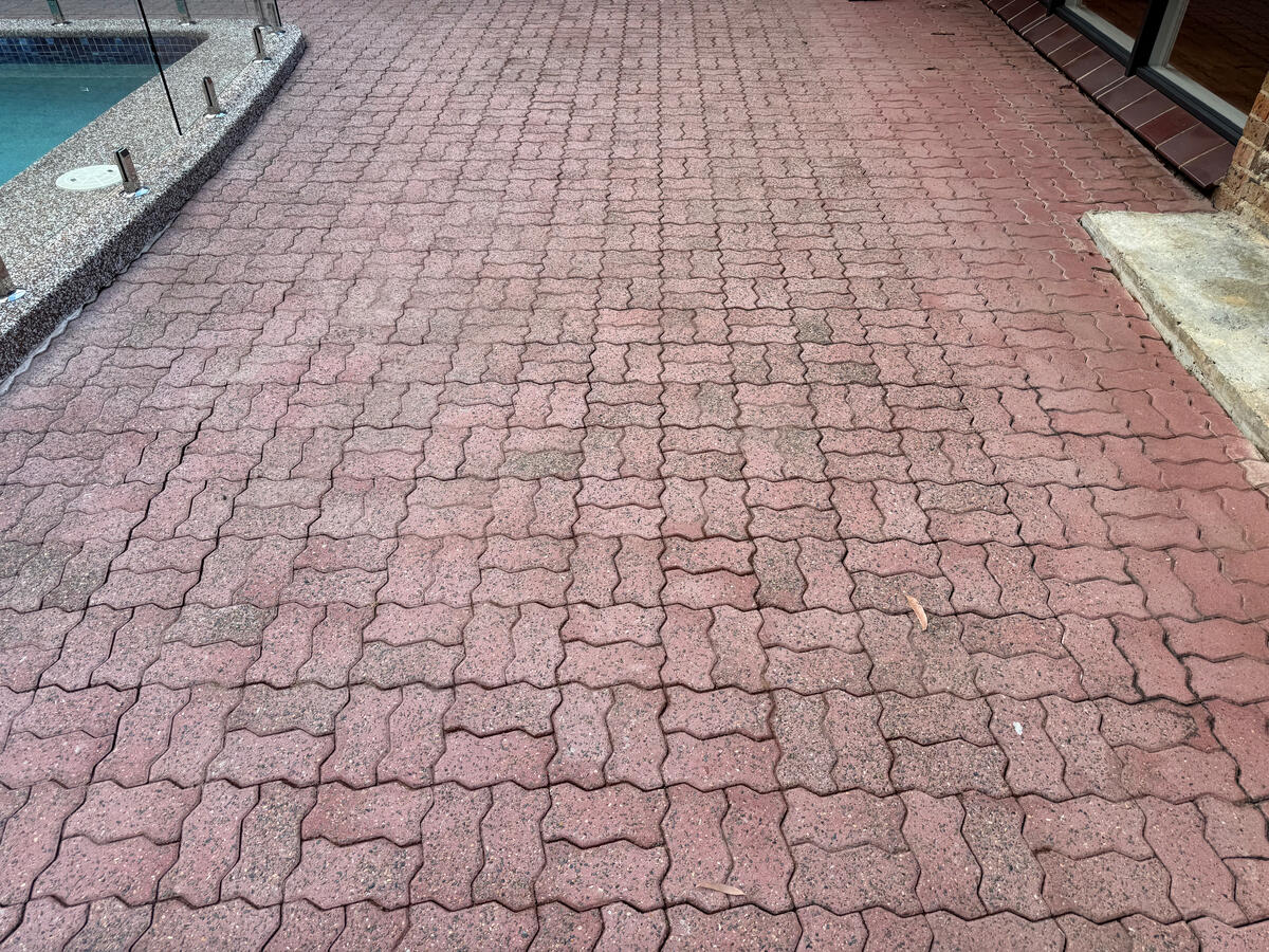 Red interlocking pool-surround pavers — after pressure wash
